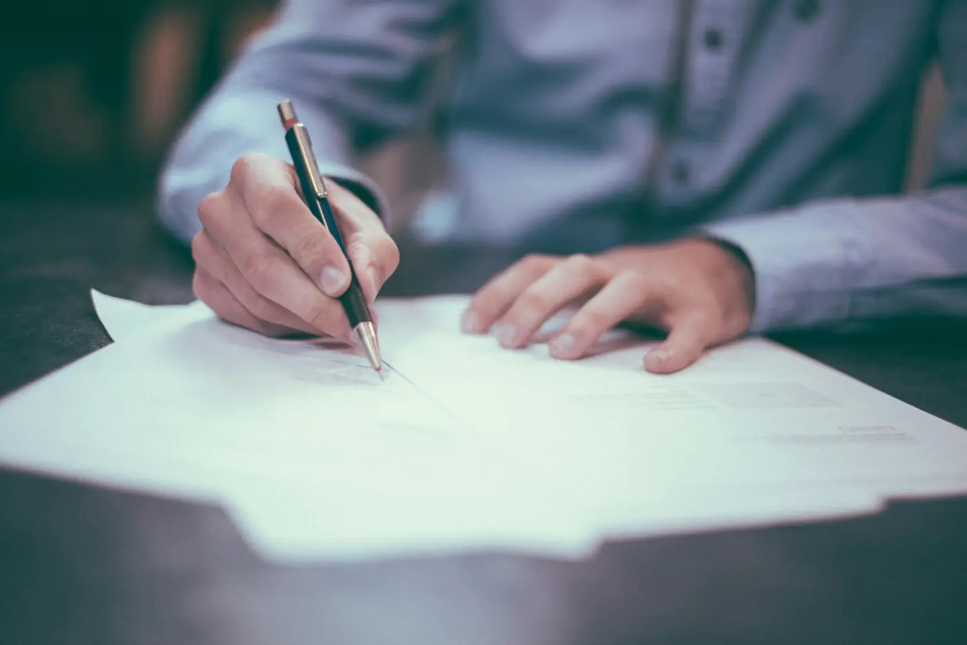 Una persona firma un documento